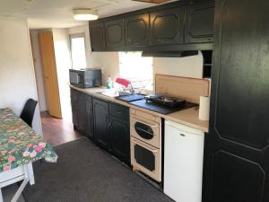 a kitchen with black cabinets and a stove top oven at Arrie in in Vellinge