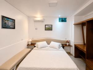 a bedroom with a bed with two pillows on it at Regine's Hotel in Itaquatiara +20 photos