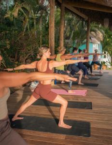 a group of people doing yoga on a boardwalk at BodyHoliday St Lucia - All Inclusive in Gros Islet