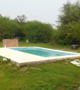 an empty swimming pool in a grassy field at El Tropezon cabaña in Resistencia
