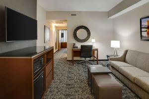 a living room with a couch and a flat screen tv at Drury Plaza Hotel Cincinnati Florence in Florence