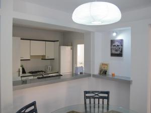 a kitchen with a table and chairs and a light fixture at Apt in Playa den Bossa next Ushuaia, beachfront, reliable host in Ibiza Town