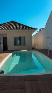 a large swimming pool in front of a house at Casa Marinho - Pé na praia in Saquarema