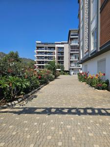 a brick walkway in front of a building with flowers at Daire 1 in Gazipasa