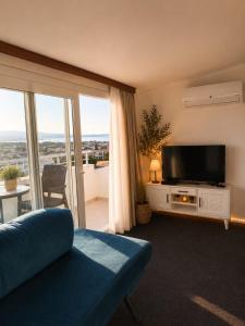 a living room with a flat screen tv and a couch at Tepe Hotel in Alaçatı