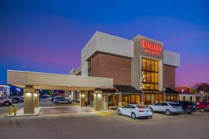 a dunkin donuts building with cars parked in a parking lot at Drury Inn & Suites Joplin in Joplin