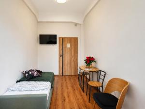 a small room with a bed and a table and chairs at Hostel KASZUBSKA in Wrocław