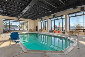 a large pool with a blue chair in a building at Drury Inn & Suites Joplin in Joplin
