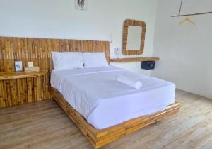 a bedroom with a large bed with a wooden headboard at Altura Esthetic Villas in Bokor +33 photos
