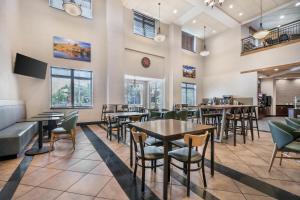 a dining room with tables and chairs and windows at Drury Plaza Hotel Flagstaff in Flagstaff
