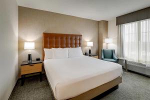 a bedroom with a large white bed and a chair at Drury Inn & Suites Montgomery in Montgomery +67 photos
