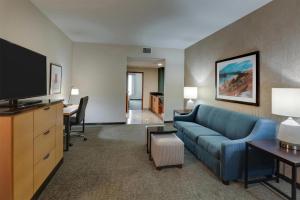 a living room with a blue couch and a tv at Drury Inn & Suites Montgomery in Montgomery