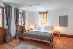 a bedroom with a bed and two windows at Krebiehls Winkelhof in Herxheim am Berg