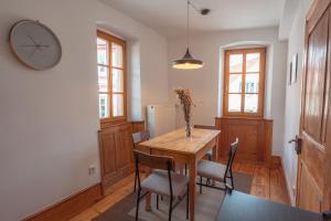 a dining room with a table and chairs and a clock at Krebiehls Winkelhof in Herxheim am Berg