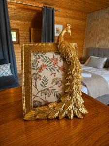 a gold statue of a peacock sitting on a table at Lake View Glamping pod Radyní bez tekoucí vody s omezenou elektřinou in Hvížďalka +19 photos