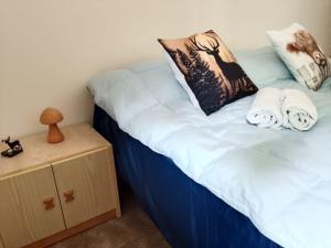 a bedroom with a bed with towels and a night stand at Foresteria del Passo Forcora in Maccagno Superiore