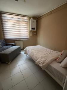 a bedroom with a bed and a chair and a window at Pendik ar Marmaray Pet Friendly in Istanbul