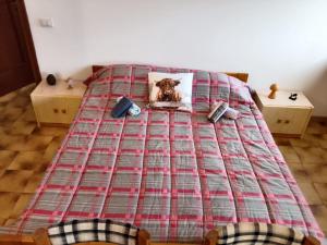 a bed with a blanket and a picture of a dog on it at Foresteria del Passo Forcora in Maccagno Superiore