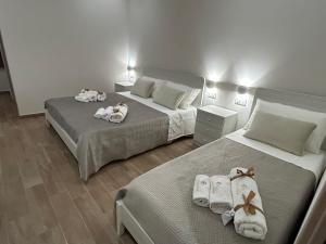 two beds in a hotel room with towels on them at B&B La Casa Nel Borgo in Morano Calabro