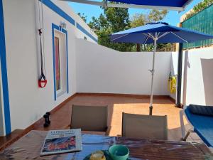 a table with a blue umbrella on a patio at Playa de Mogán in Playa del Cura