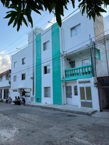 a white and green building with people sitting in front of it at Casa Laurel in Cancún