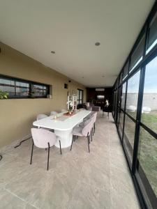 a dining room with a white table and chairs at Las Moras in Ezeiza