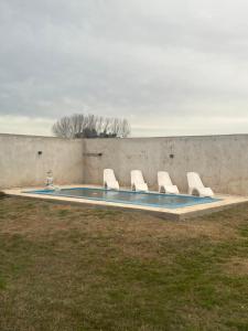 a group of chairs sitting in a swimming pool at Las Moras in Ezeiza