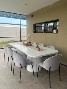 a dining room with a white table and chairs at Las Moras in Ezeiza +9 photos