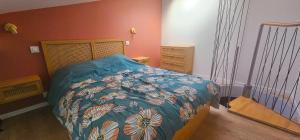 a bedroom with a bed with a blue comforter at La mie du Hom in Thury-Harcourt