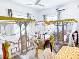 a room with chairs and a table and windows at Visitors Inn Zanzibar in Jambiani