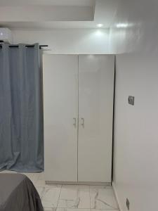 a white cabinet in a room next to a bed at Résidence SG2 in Thiès