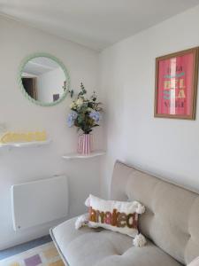 a living room with a couch and a mirror at Le cocon du pas de Lauzens in Aouste-sur-Sye