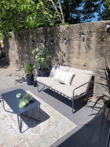 a couch and a table on a patio at Le cocon du pas de Lauzens in Aouste-sur-Sye +25 photos