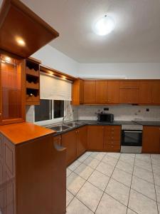 a large kitchen with wooden cabinets and a sink at Suva Apartments Chania in Agia Marina Nea Kydonias