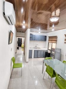 a kitchen with a glass table and green chairs at Raoul Immobilier JDMK in Brazzaville