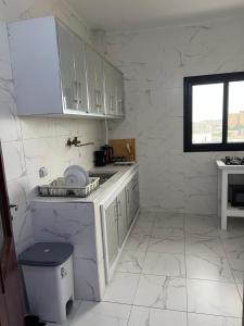 a white kitchen with white cabinets and a counter at Résidence SG2 in Thiès
