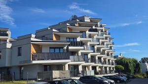 a large building with cars parked in front of it at Apartament Kaskady75 in Łańcut