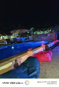 a person laying next to a swimming pool at night at Escape-Cabins in Ko Lanta