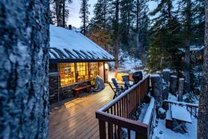 a log cabin with a deck in the snow at Hideaway Above The Stream Sundance, Utah in Sundance