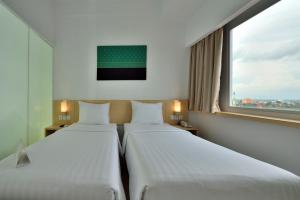 Ένα ή περισσότερα κρεβάτια σε δωμάτιο στο Whiz Prime Hotel Sudirman Pekanbaru