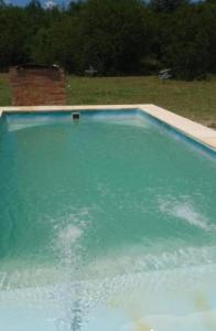 a swimming pool filled with water in a field at El Tropezon cabaña in Resistencia