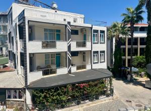 a white apartment building with a balcony and palm trees at Delphin Hotel Side in Side
