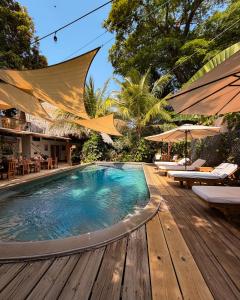 a swimming pool with a wooden deck and a resort at Hotel Michanti in El Zonte
