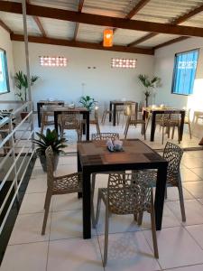 a dining room with tables and chairs and windows at Pousada Brisa dos Mares Macaé in Macaé