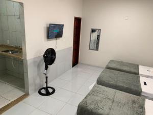 a room with a bed and a fan and a sink at Pousada Brisa dos Mares Macaé in Macaé