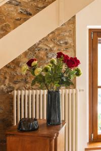 a vase of flowers on a table next to a radiator at Casa Il Borgo 1 in Tavernelle
