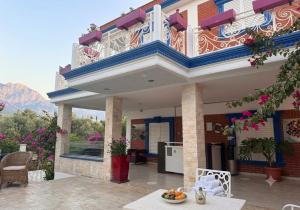 a building with a balcony with a bowl of fruit on a table at Grecia's Dhermi in Dhërmi +10 photos