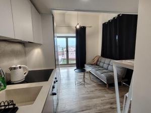 a kitchen and living room with a couch and a table at 2 1D2 Mini Condos- Large Studio SW facing in Tivat