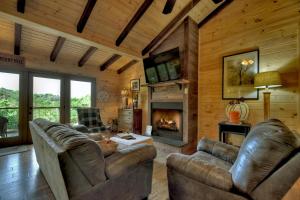 a living room with leather furniture and a fireplace at Blueberry Hill Fire Pit MTN Views Grill in McCaysville