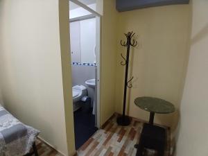 a bathroom with a toilet and a table in a room at Hospedaje Vicente in Lunahuaná
